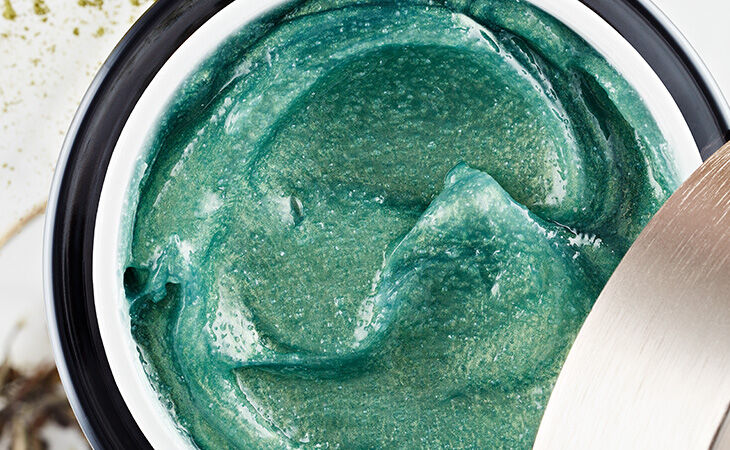 A close-up of a green Rituals body scrub for soft and smooth glowing skin.